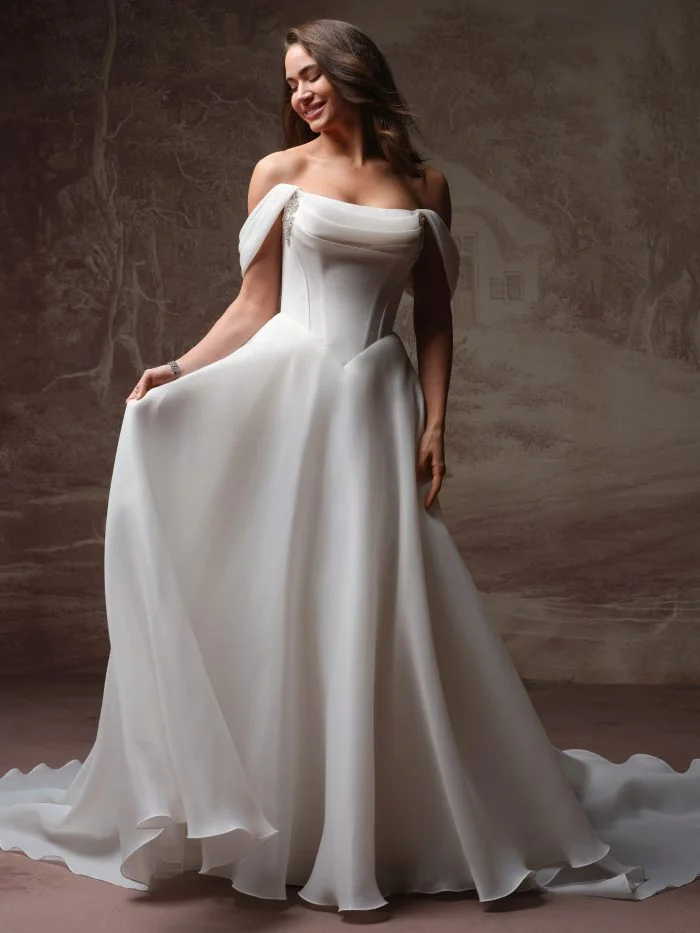 Bride wearing Abilene by Maggie Sottero, a romantic A-line wedding gown with a structured basque waist and voluminous organza skirt.