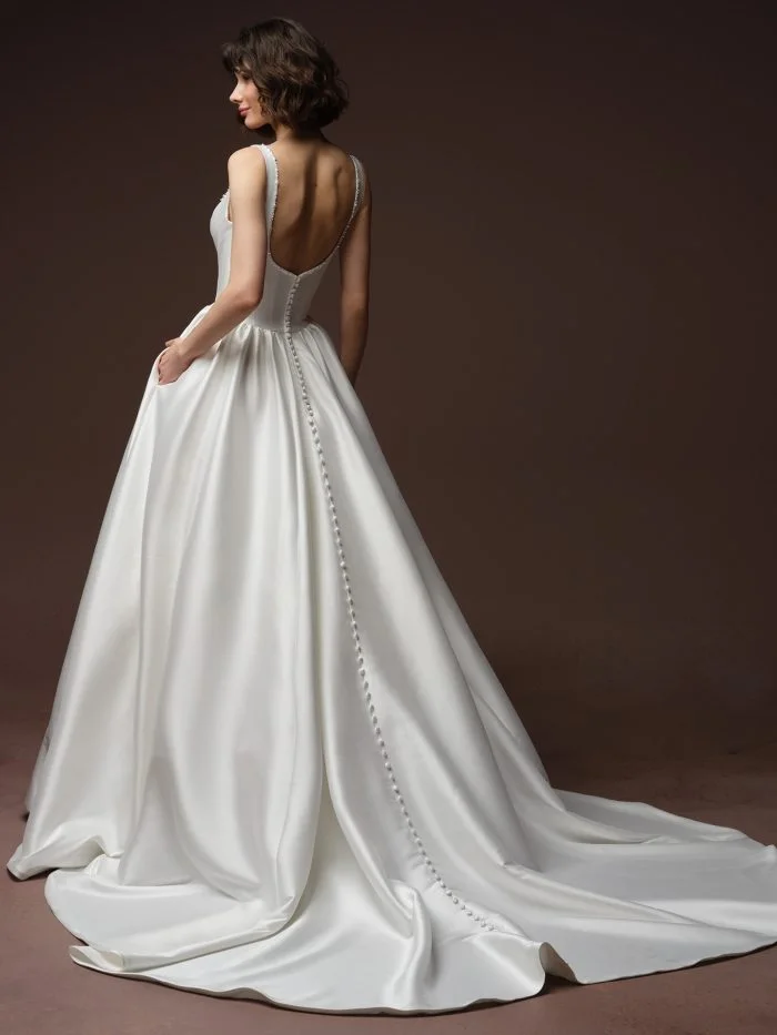 Back view of Zurielle by Maggie Sottero showcasing elegant tank straps and covered buttons trailing down the ballgown skirt.