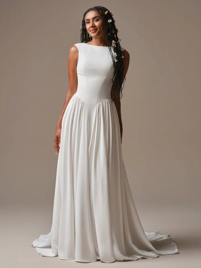 Bride wearing Shay by Rebecca Ingram, a timeless A-line wedding gown with a modest neckline and sleek crepe fabric.