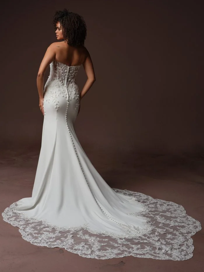 Back view of Blair by Sottero and Midgley showcasing a plunging illusion lace back, exposed boning, and covered buttons.