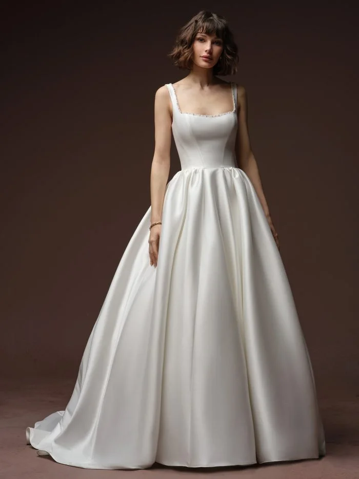 Bride wearing Zurielle by Maggie Sottero, a timeless Mikado ballgown wedding dress with a full skirt and embellished neckline.