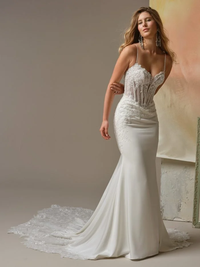 Bride wearing India by Maggie Sottero, a fitted satin sheath wedding gown with intricate beaded lace embellishments.