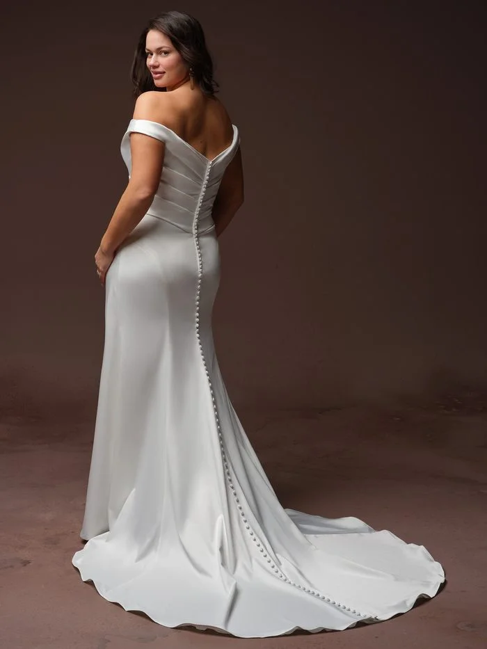 Back view of the Rebecca Ingram Clementine sheath wedding gown featuring covered buttons, elegant draping, and a sleek train.
