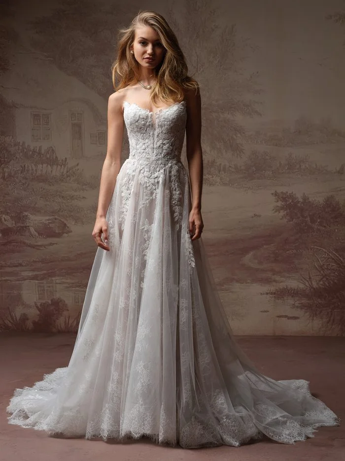 Maggie Sottero Hadley A-line wedding gown featuring floral lace appliqués, a strapless sweetheart neckline, and an airy tulle skirt that flatters petite brides.