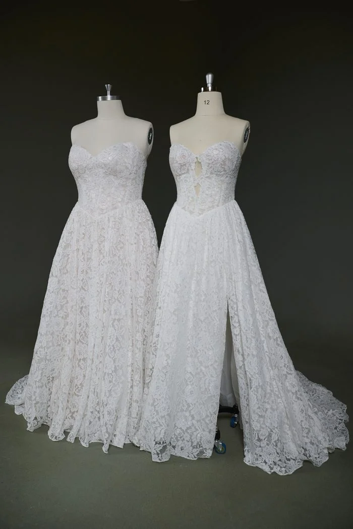 Front-angle comparison of two Narelle by Rebecca Ingram wedding gowns displayed on dress forms. Both gowns feature a strapless sweetheart neckline, floral lace fabric, and a flowing A-line skirt. The left version has a seamless lace bodice and full skirt, while the right version incorporates a keyhole opening at the center bodice and a high thigh slit in the skirt, demonstrating alternative customization options.