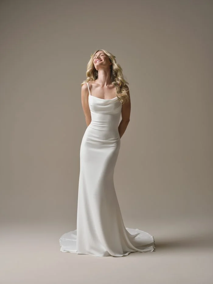 Front view of the Rebecca Ingram Brenda sheath wedding dress featuring a draped scoop neckline, spaghetti straps, and a sleek fitted silhouette.
