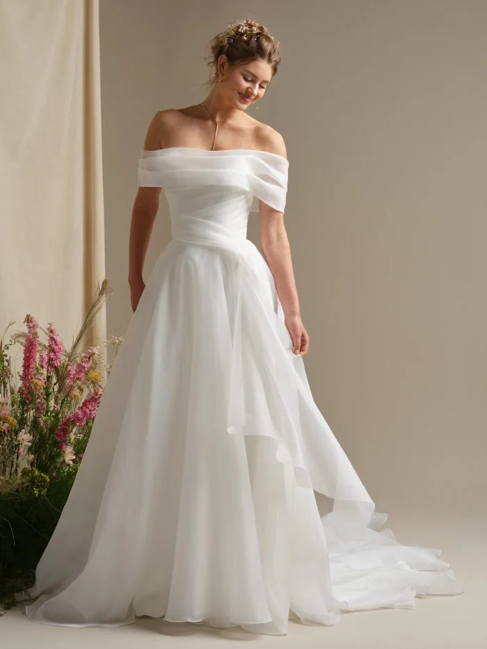 Rebecca Ingram Dezi wedding dress featuring a sleek fitted silhouette, draped neckline, and minimalist satin finish.