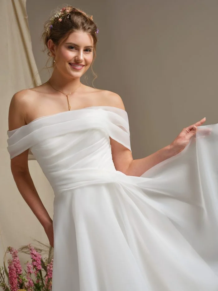 Rebecca Ingram Dezi wedding dress featuring a sleek fitted silhouette, draped neckline, and minimalist satin finish.