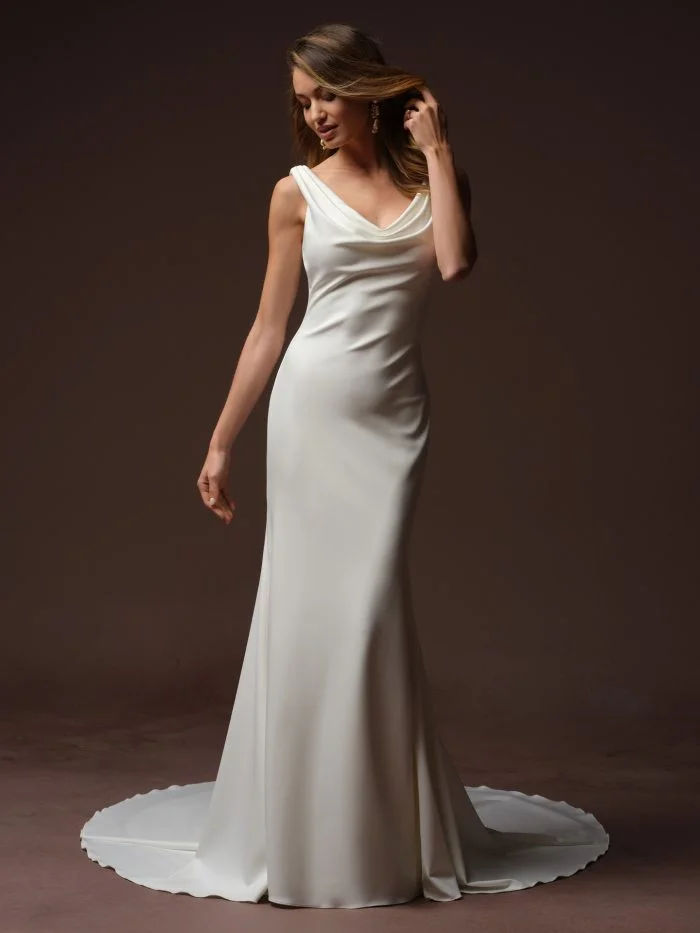 Full-length view of the Rebecca Ingram Tiana sheath wedding dress featuring a soft scoop neckline, draped satin bodice, sleek silhouette.