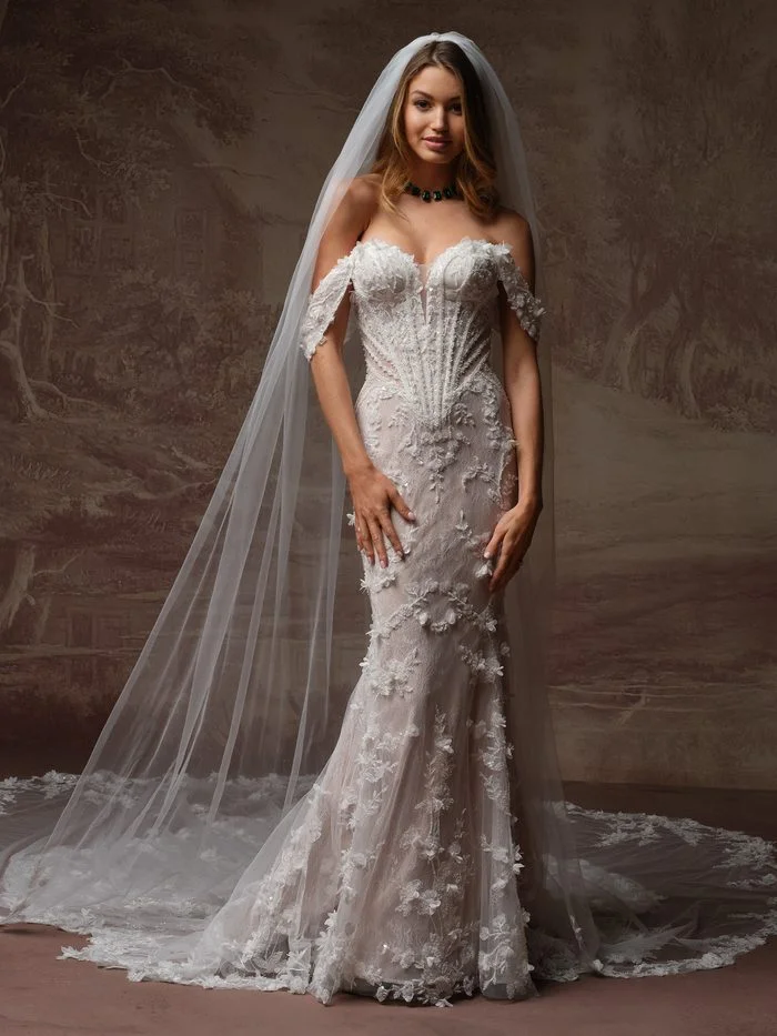 Stasia by Maggie Sottero fit-and-flare wedding dress paired with a cathedral-length veil and floral lace appliqués.