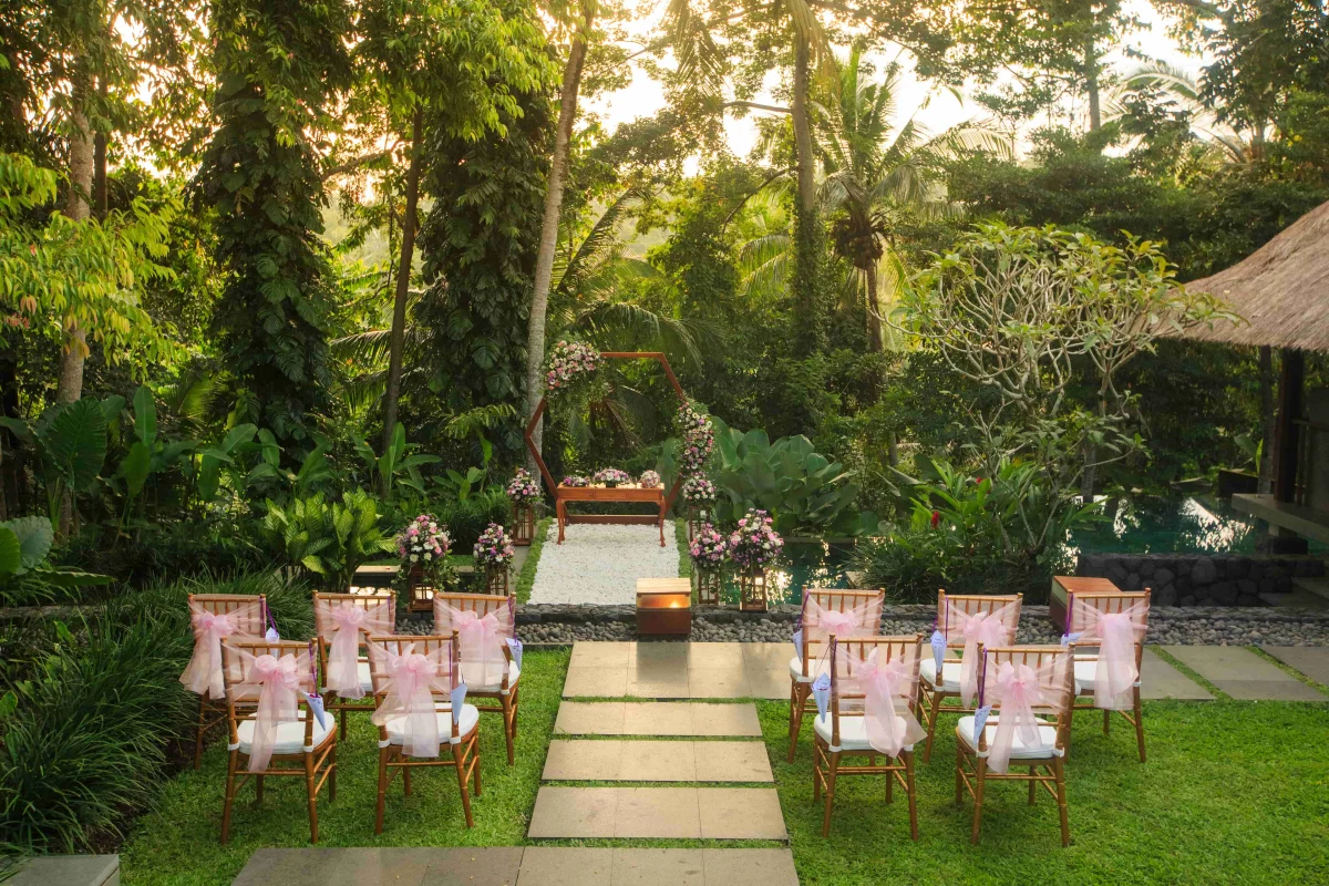 wedding-reception-setup-with-a-hexagon-wedding-arch-decorated-with-white-and-pink-flowers-on-a-pool-at-kayumanis-ubud