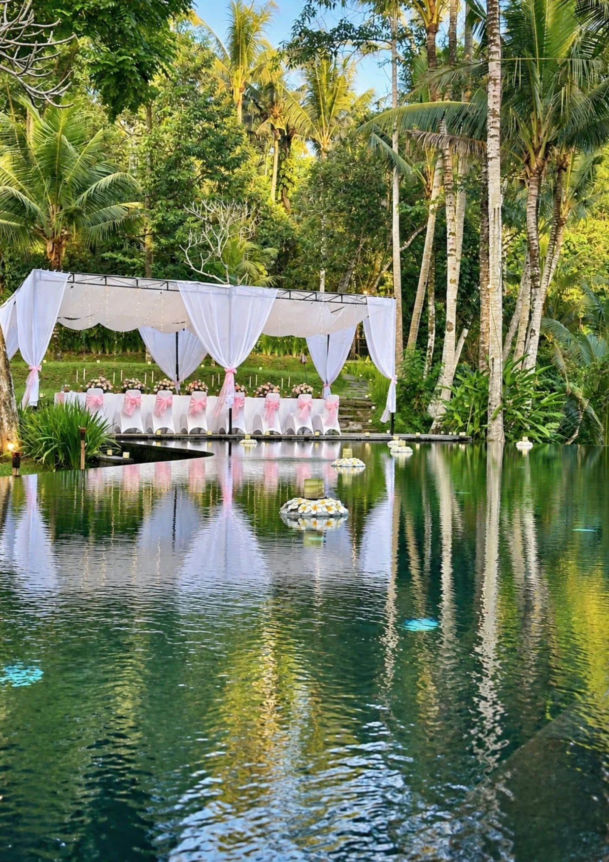 covered-wedding-reception-setup-by-the-main-pool-surrounded-by-trees-at-kayumanis-ubud