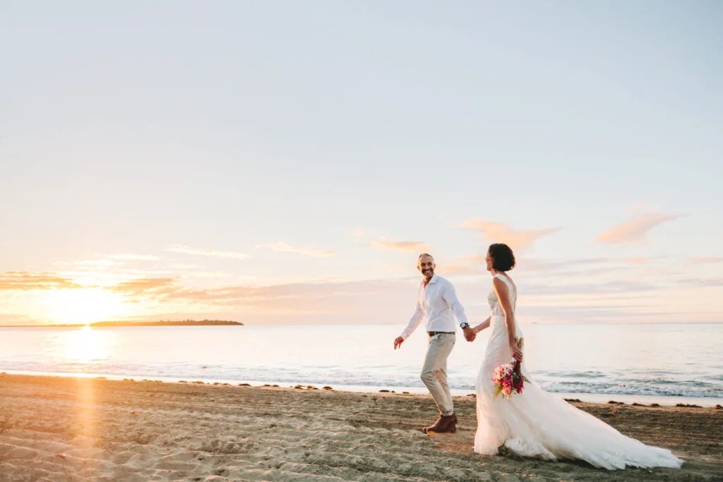 hilton-fiji-weddings-bride-and-groom-walking-on-the-beach-shore-during-sunset
