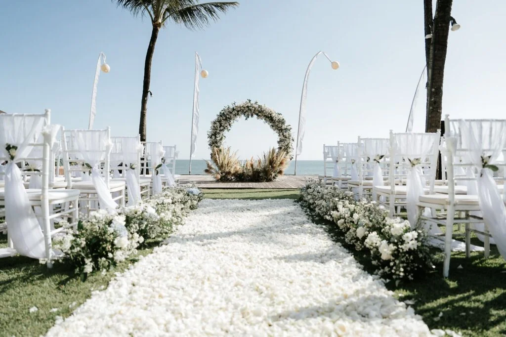 wedding setup with circle arch and white flower decorations with the beach in the background at The Samaya Seminyak