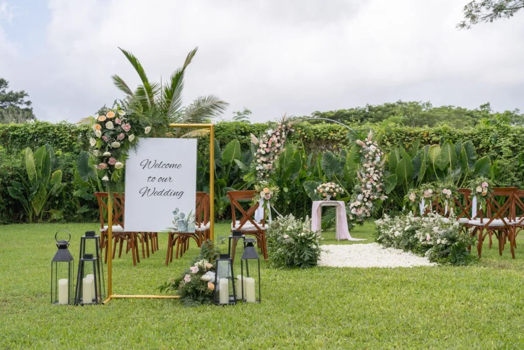welcome posted - circle wedding arch with white and pastel colored flower decoration - garden wedding at Kayumanis Jimbaran