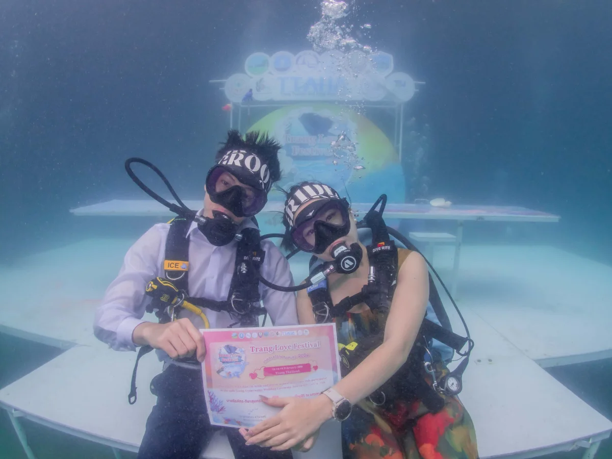 bride-and-groom-holding-their-wedding-certificate-underwater-at-trang-thailand