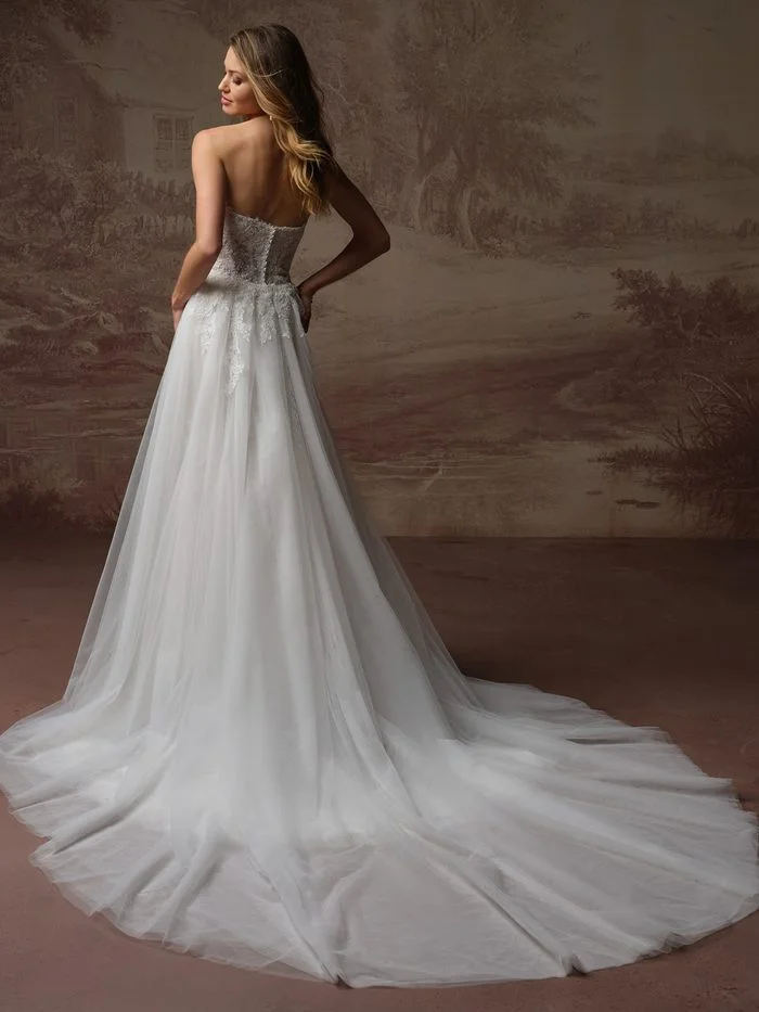 Back view of the Esmeralda Lane boho floral wedding dress showcasing a detachable tulle train, floral lace detailing, and a sweeping chapel-length silhouette for added drama and movement.