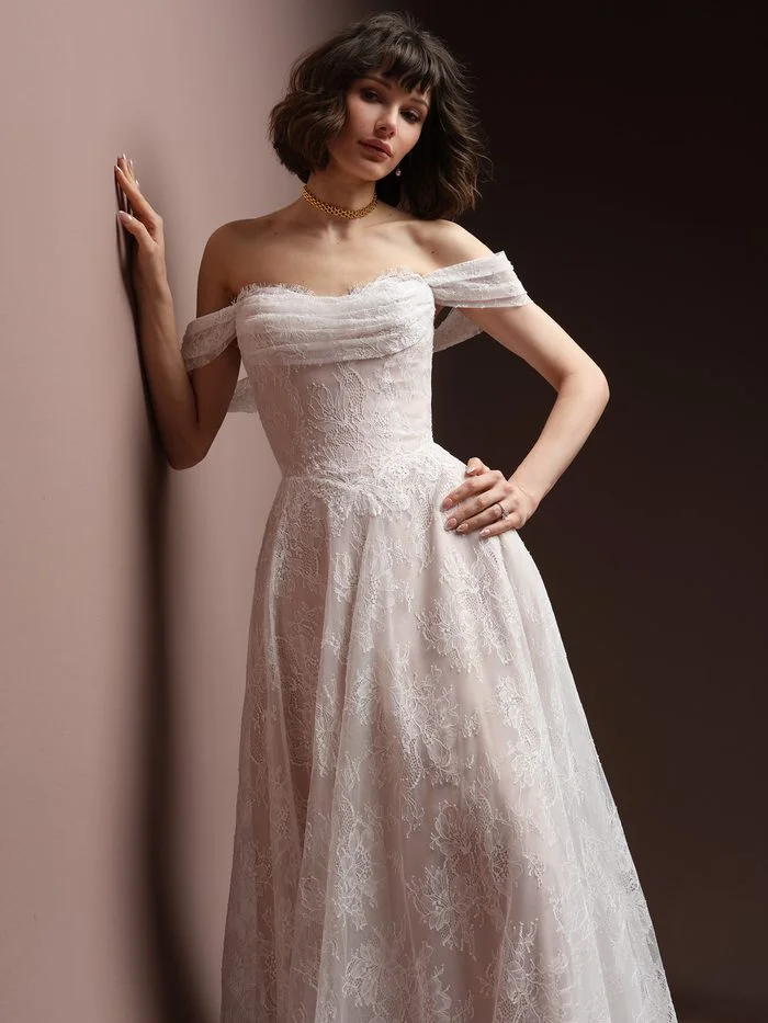 Maelle boho floral wedding dress with detachable off-the-shoulder cap sleeves, featuring delicate allover floral lace, a draped sweetheart neckline, and a soft A-line silhouette for a romantic bridal look.