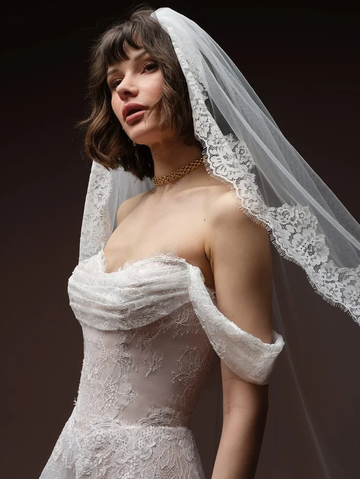 Maelle boho floral wedding dress with detachable off-the-shoulder cap sleeves, featuring delicate allover floral lace, a draped sweetheart neckline, and a soft A-line silhouette for a romantic bridal look.