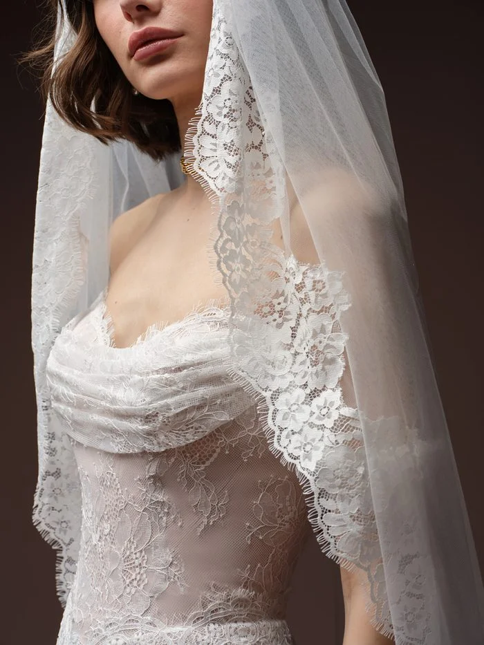 Minuet wedding veil with delicate floral lace edging, styled with the Maelle boho floral wedding dress to showcase romantic lace detailing and soft cathedral-length tulle.