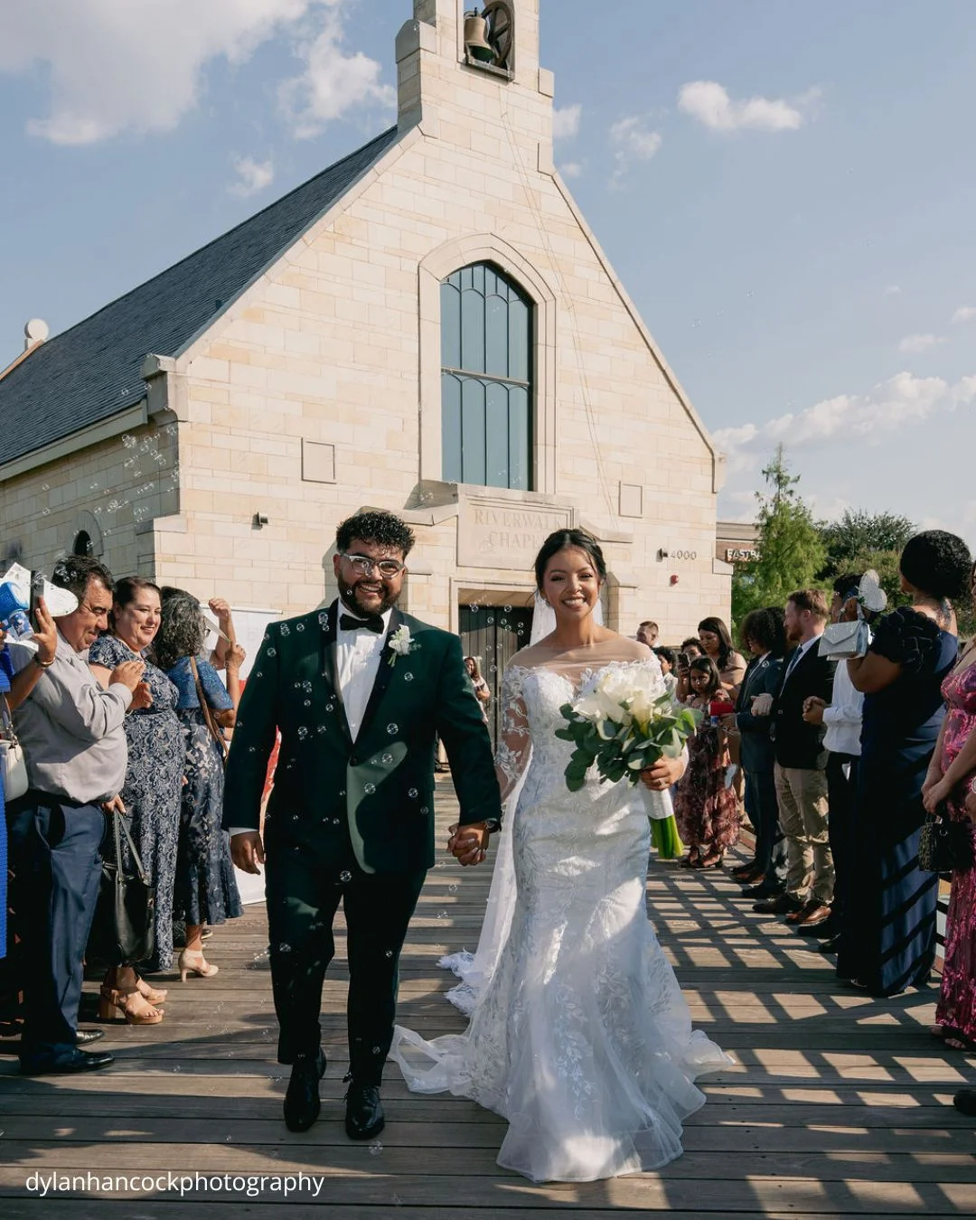 bride and groom walking hand in hand toward church dylanhancockphotography