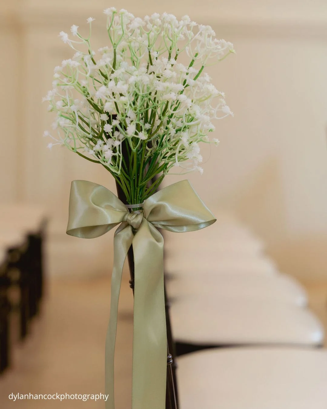wedding chair decorated with baby’s breath and green ribbon dylanhancockphotography