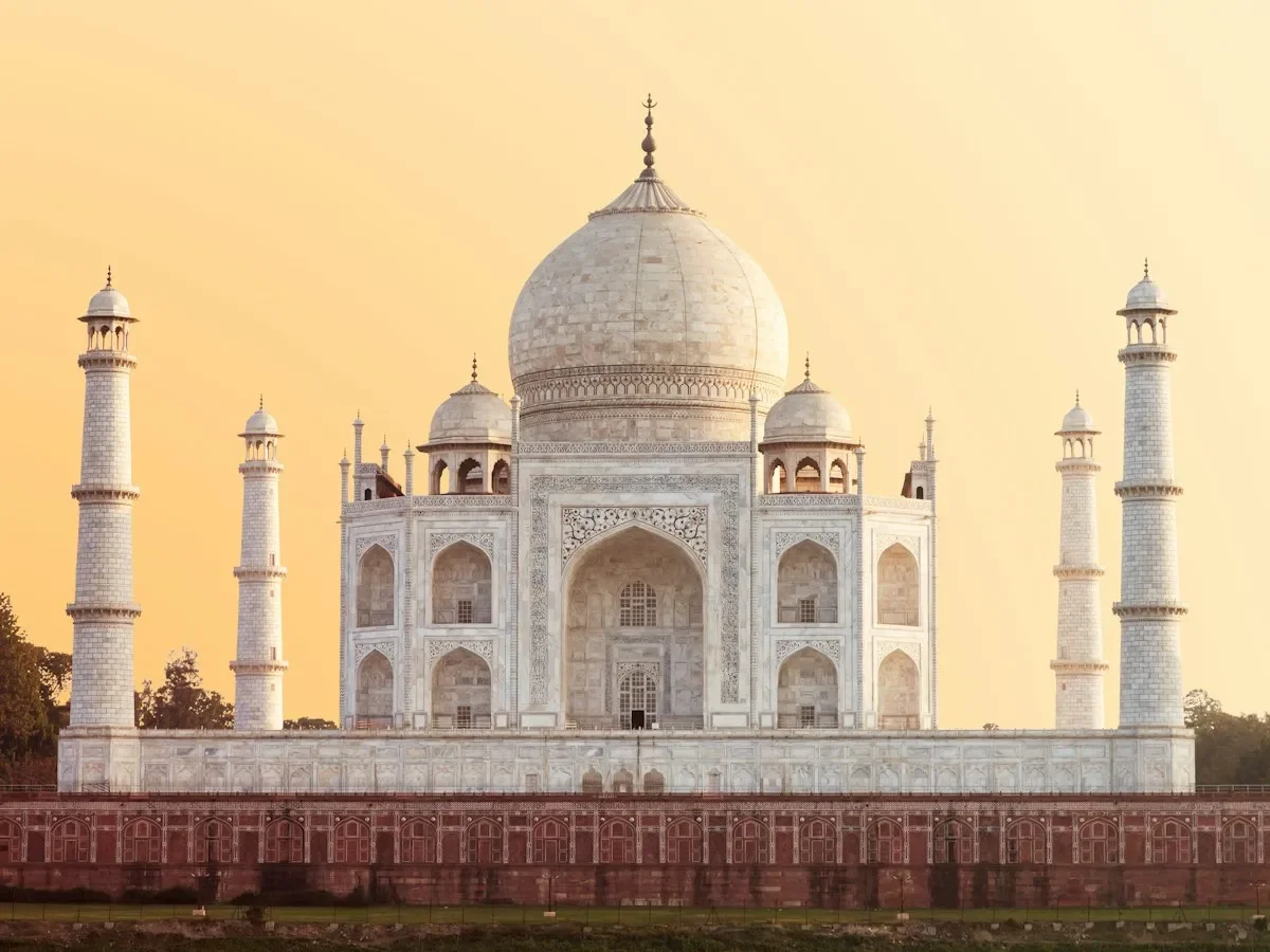 The white marble Taj Mahal in Agra under a warm golden sky