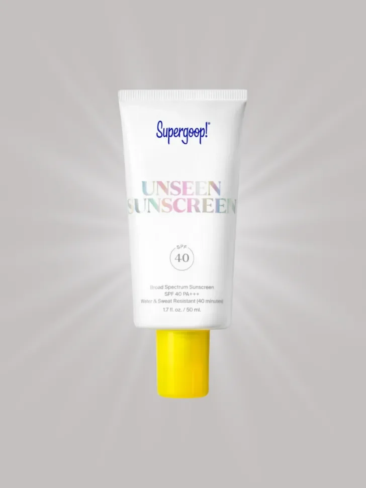 A tube of Supergoop! Unseen Sunscreen, featuring a white bottle with a yellow cap.