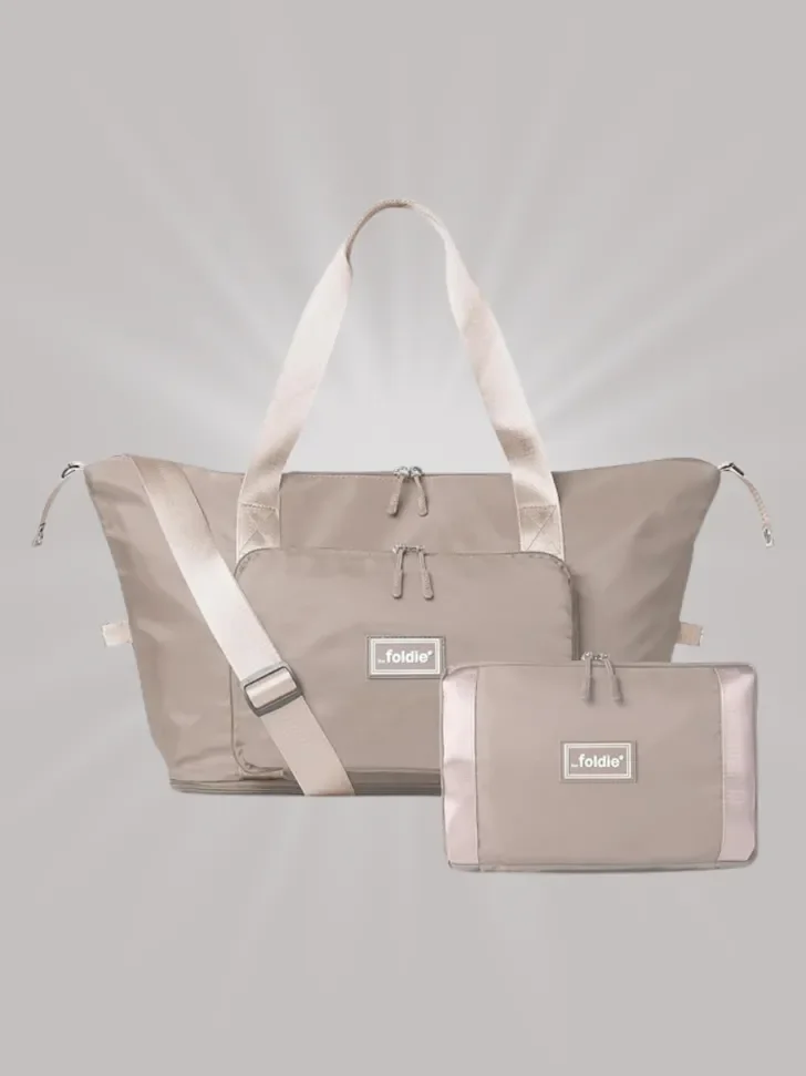 Beige foldable travel tote bag that collapses into a compact pouch.